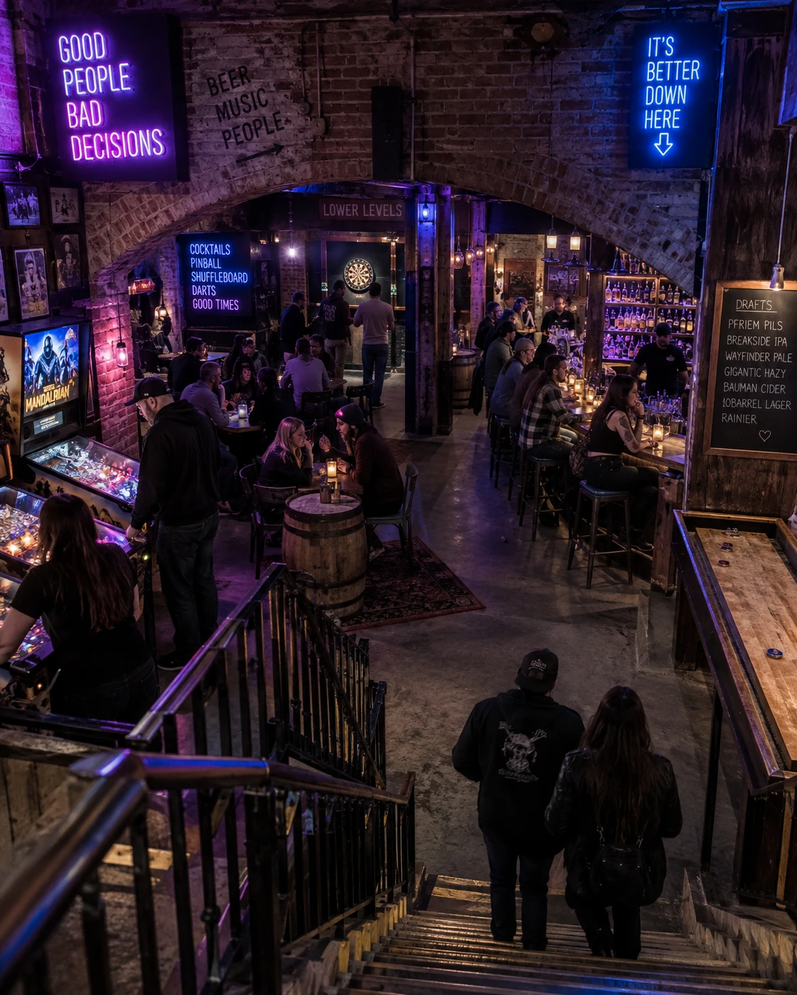 Underground bar in Portland with brick arches, games, drinks and people descending stairs